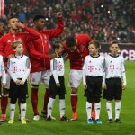 Bartek vom LFZ Kids Club an der Hand von Robert Lewandowski