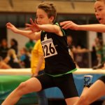 Jugendlicher Läufer über der Hürde